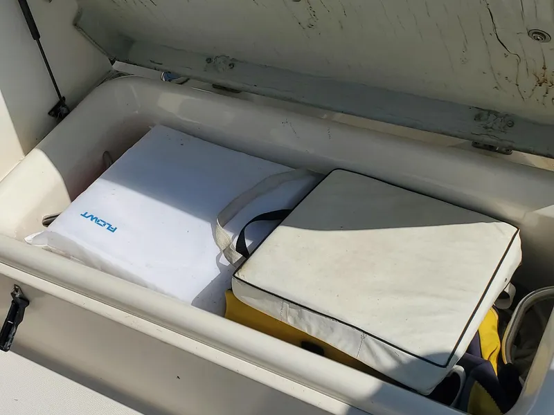 Slide: The Image of Storage compartment on a 1999 Pursuit 2470 Walkaround boat with cushions and gear. - 15