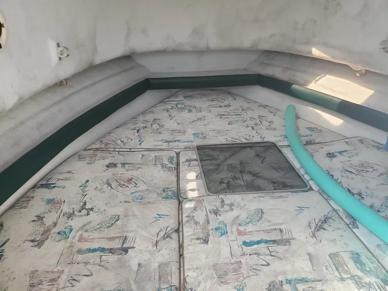 Slide: The Image of Interior cabin of 1999 Pursuit 2470 Walkaround boat with patterned cushions. - 18