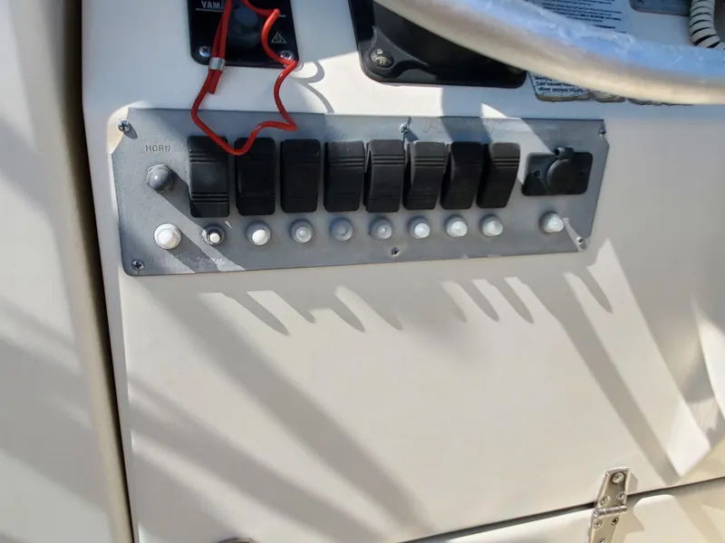 Slide: The Image of Control panel of a 1999 Pursuit 2470 Walkaround boat with switches and buttons. - 20