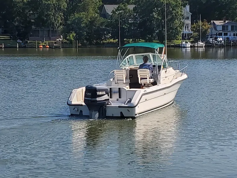 Slide: The Image of 1999 Pursuit 2470 Walkaround boat with Yamaha engine on a calm lake. - 3