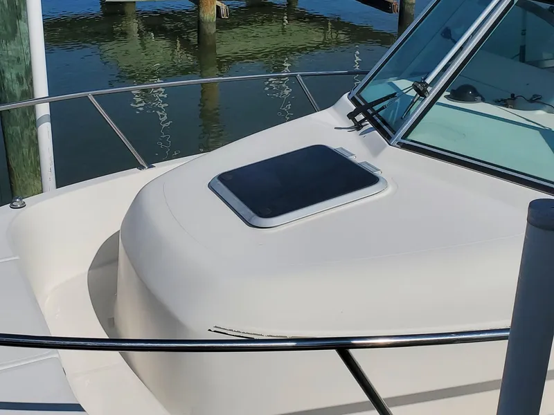 Slide: The Image of 1999 Pursuit 2470 Walkaround boat, docked, showing cabin and windshield. - 5