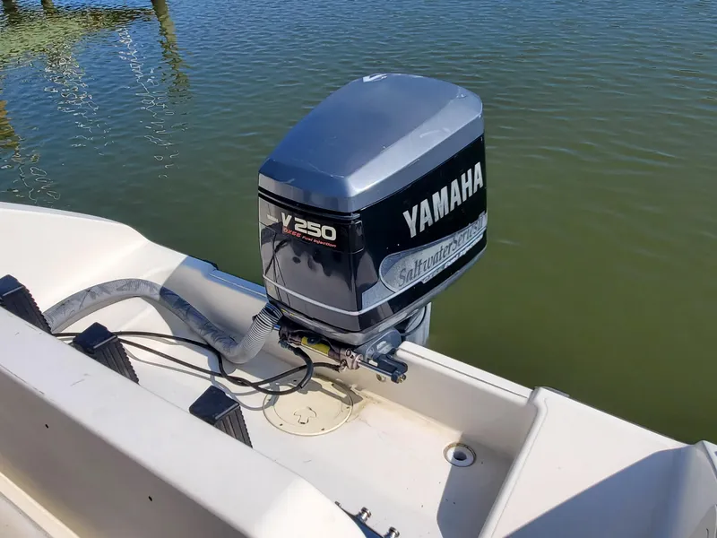 Slide: The Image of 1999 Pursuit 2470 Walkaround with Yamaha V250 outboard motor on calm water. - 6