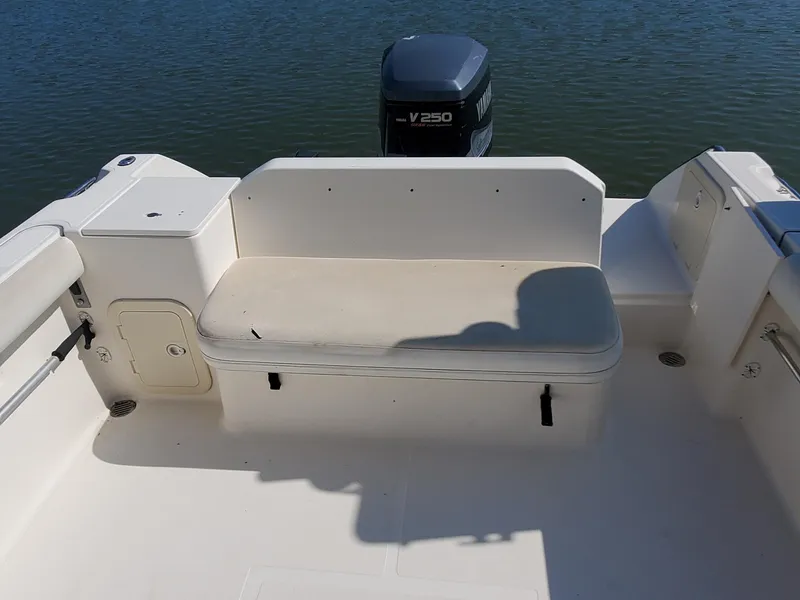 Slide: The Image of 1999 Pursuit 2470 Walkaround boat interior with seating and outboard motor. - 8