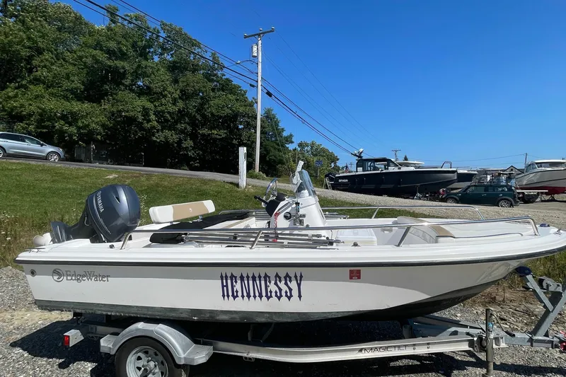 Slide: The Image of 2022 Edgewater 158CS boat named "Hennessy" on a trailer, parked outdoors. - 3