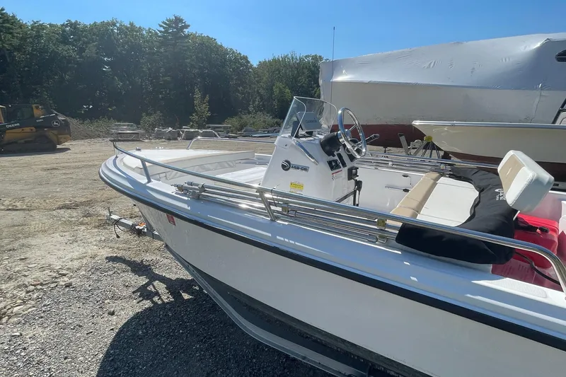 Slide: The Image of 2022 Edgewater 158CS boat parked outdoors, featuring sleek design and modern controls. - 6