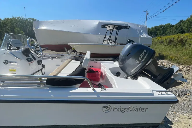 Slide: The Image of 2022 Edgewater 158CS boat with Yamaha engine, parked outdoors on a sunny day. - 7