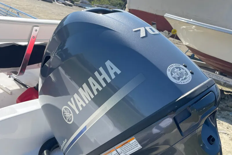 Slide: The Image of Yamaha 70 outboard motor on 2022 Edgewater 158CS boat, docked outdoors. - 9