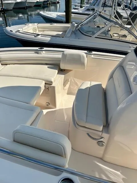 Slide: The Image of 2024 Grady-White Fisherman 216 boat interior with cushioned seating in a marina setting. - 11