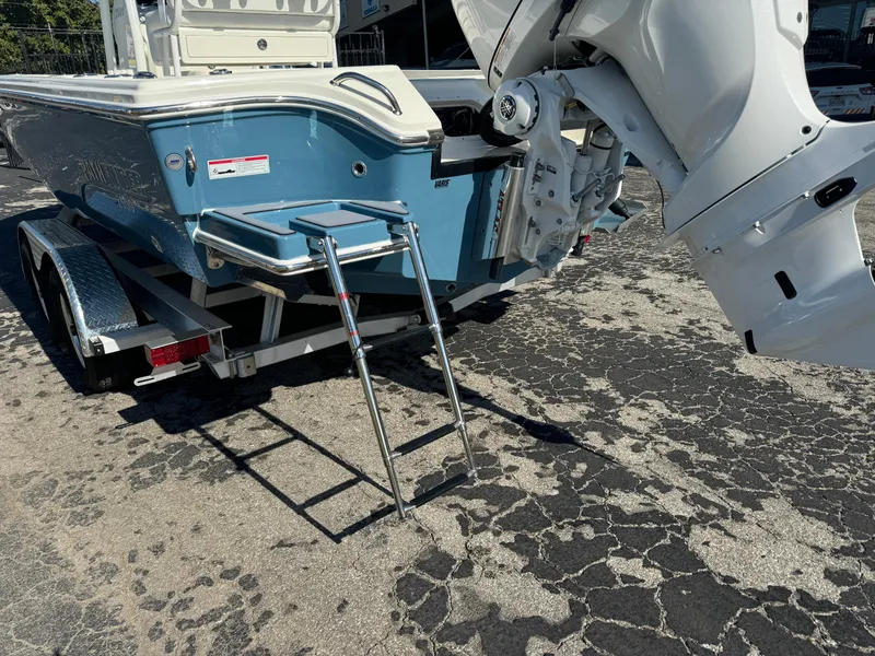 Slide: The Image of 2025 Pathfinder 2500 Hybrid boat with ladder and trailer, parked on asphalt. - 15