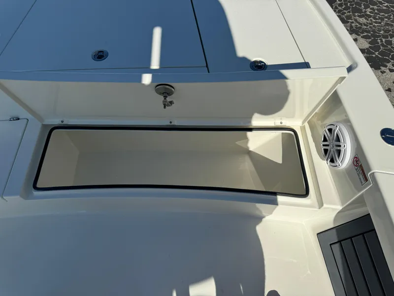 Slide: The Image of Pathfinder 2500 Hybrid 2025 boat storage compartment with speaker, open lid, and shadow. - 30