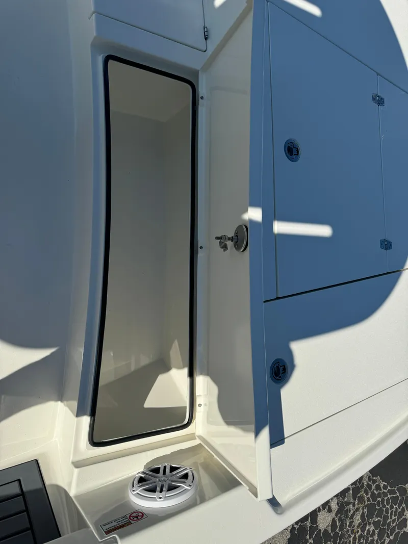 Slide: The Image of 2025 Pathfinder 2500 Hybrid boat storage compartment with open hatch and drain. - 33