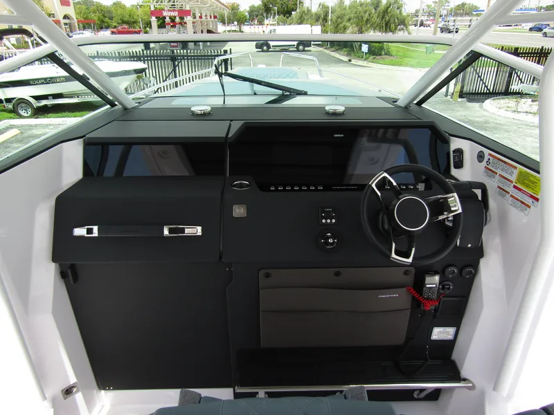 Slide: The Image of 2024 Axopar 37 Sun Top helm with modern steering and dashboard controls. - 12