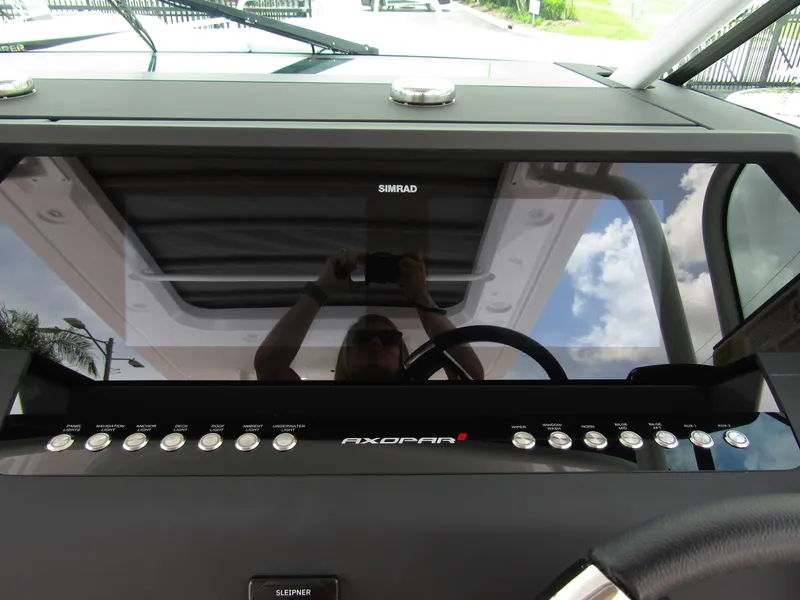 Slide: The Image of 2024 Axopar 37 Sun Top dashboard with Simrad display and control buttons. - 13