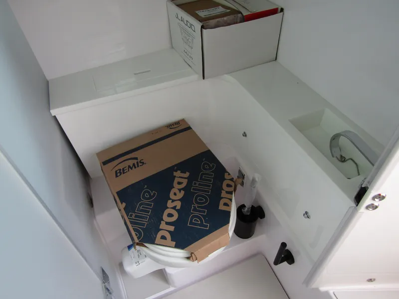 Slide: The Image of 2024 Axopar 37 Sun Top storage area with boxes and plumbing fixtures. - 21