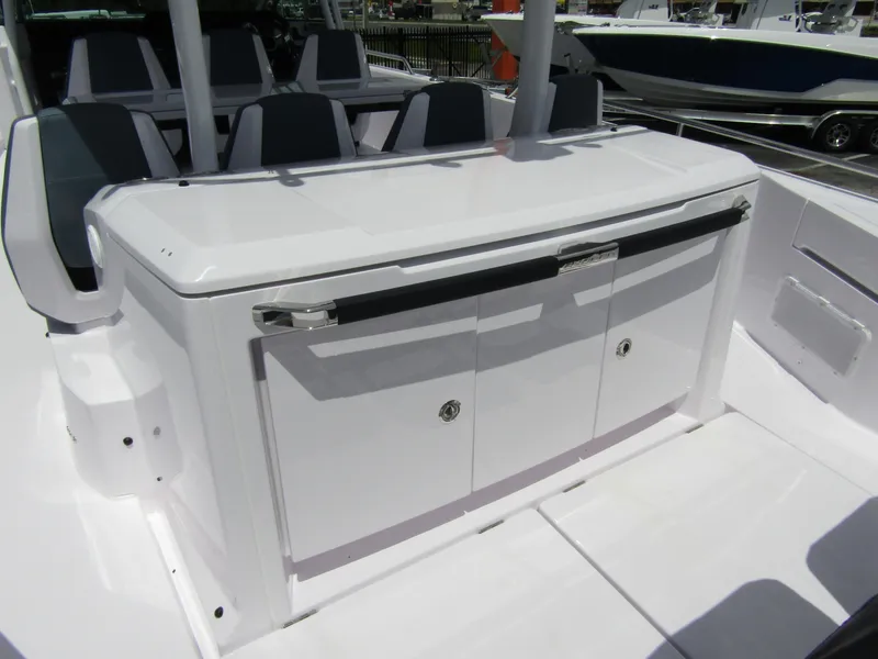 Slide: The Image of 2024 Axopar 37 Sun Top boat interior with sleek white cabinetry and seating. - 25