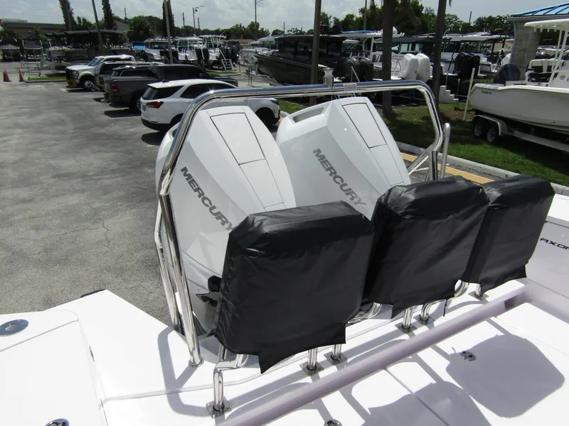 Slide: The Image of 2024 Axopar 37 Sun Top with dual Mercury engines in a marina setting. - 30