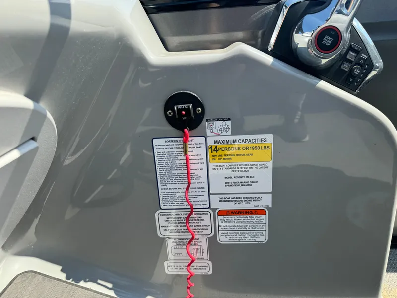 Slide: The Image of 2023 Regency 250 DL3 boat dashboard with safety labels and controls. - 23