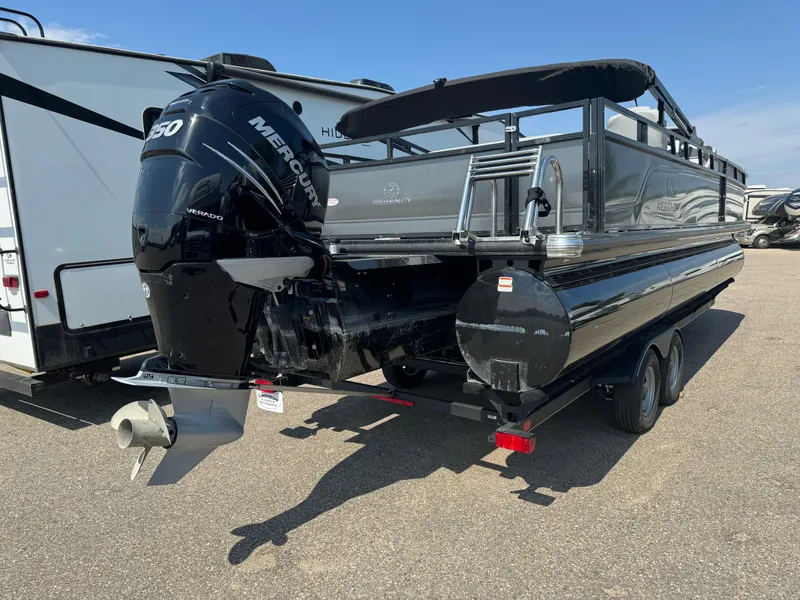 Slide: The Image of 2023 Regency 250 DL3 pontoon boat with Mercury outboard motor, parked on a trailer. - 4