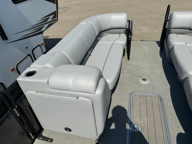 Slide: The Image of 2023 Regency 250 DL3 pontoon boat with gray seating and deck view. - 6