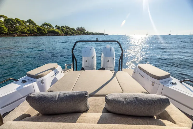 Slide: The Image of 2024 Axopar 37 Sun Top boat with sunbed, ocean view, and twin engines. - 8