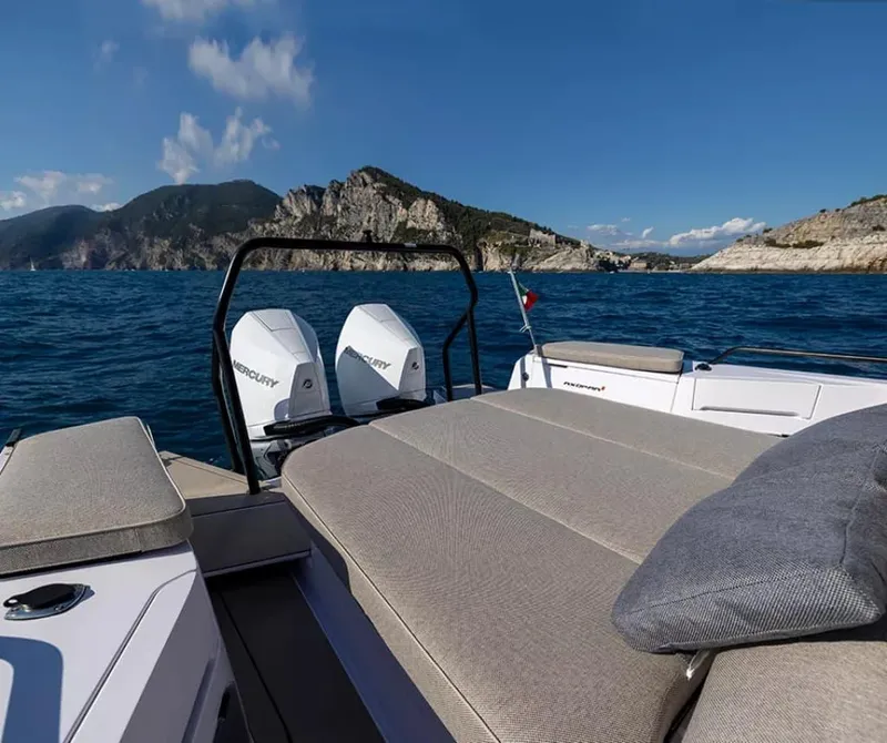 Slide: The Image of 2024 Axopar 37 Sun Top boat with twin Mercury engines, scenic coastal backdrop. - 9