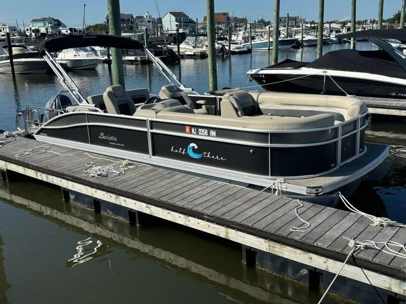 Slide: The Image of 2021 Barletta C24UC pontoon boat docked in marina. - 2