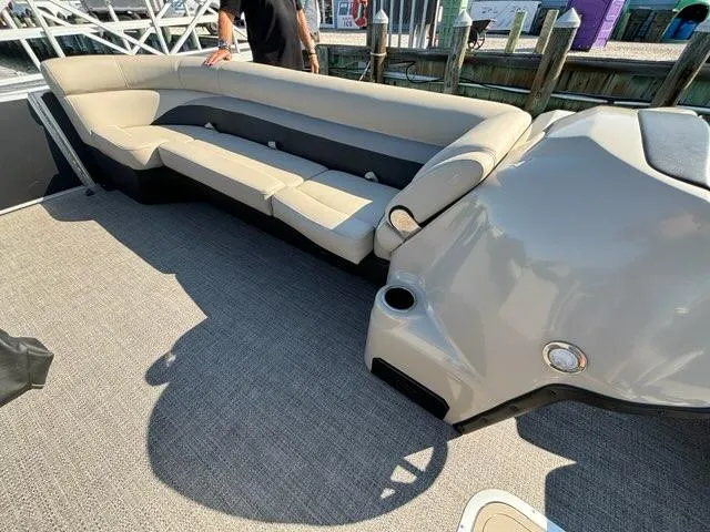 Slide: The Image of 2021 Barletta C24UC pontoon boat interior with beige seating and carpeted flooring. - 9