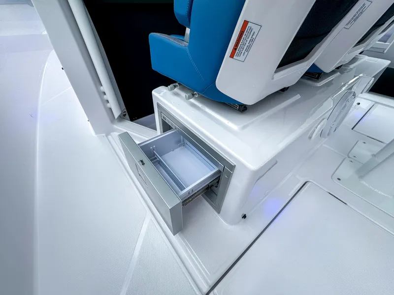 Slide: The Image of 2024 Axopar 37 Sun Top interior with open storage drawer under blue seat. - 13