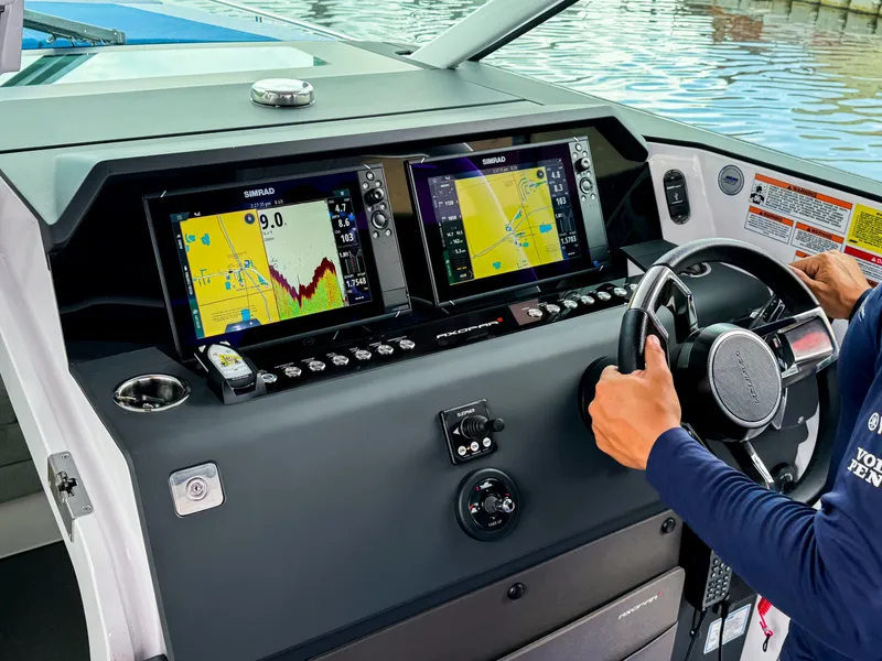 Slide: The Image of 2024 Axopar 37 Sun Top dashboard with navigation screens and steering wheel. - 14
