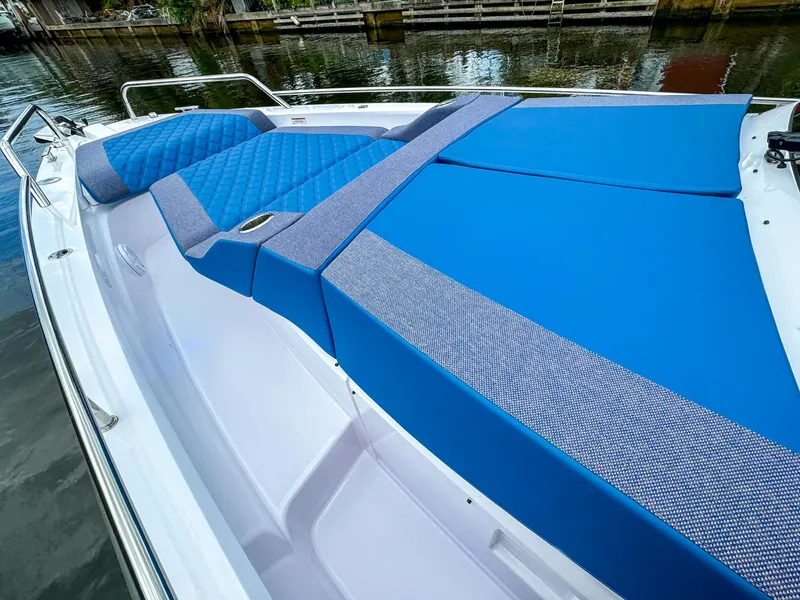 Slide: The Image of 2024 Axopar 37 Sun Top boat with blue cushioned seating on deck. - 19