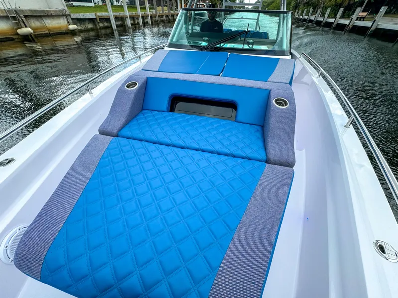 Slide: The Image of 2024 Axopar 37 Sun Top boat with blue cushioned seating on deck. - 20
