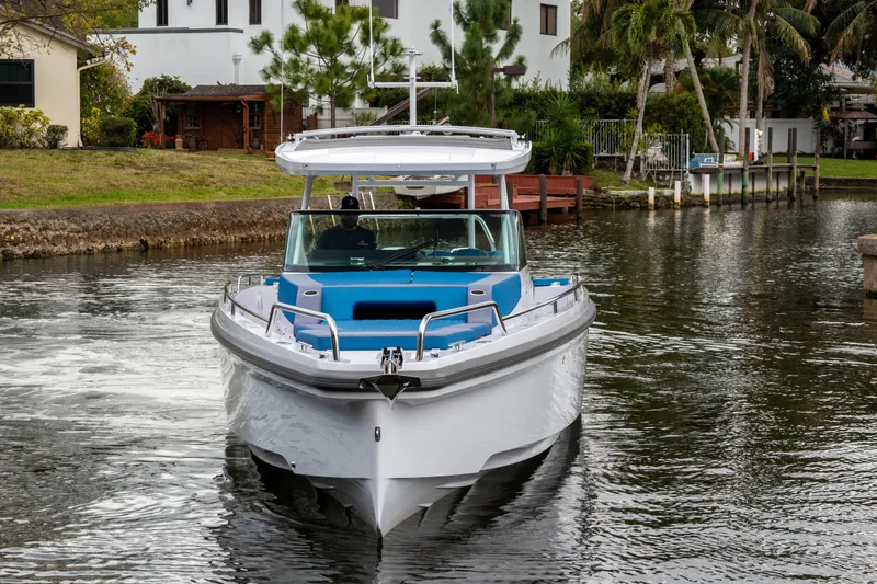 Slide: The Image of 2024 Axopar 37 Sun Top boat cruising on a calm waterway. - 21