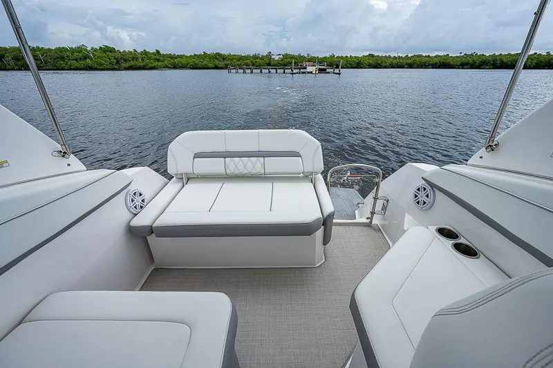 Slide: The Image of 2022 Regal 26 XO boat interior with comfortable seating on a serene lake. - 11