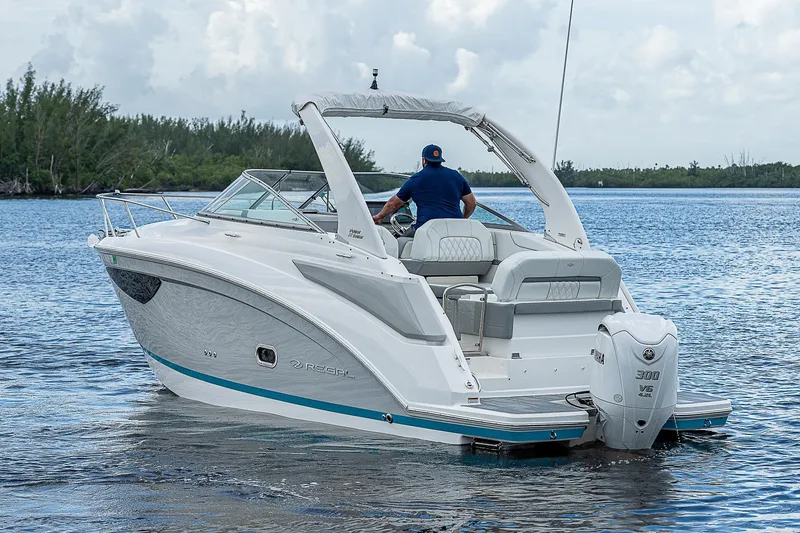 Slide: The Image of 2022 Regal 26 XO boat cruising on a calm lake with a clear sky. - 44