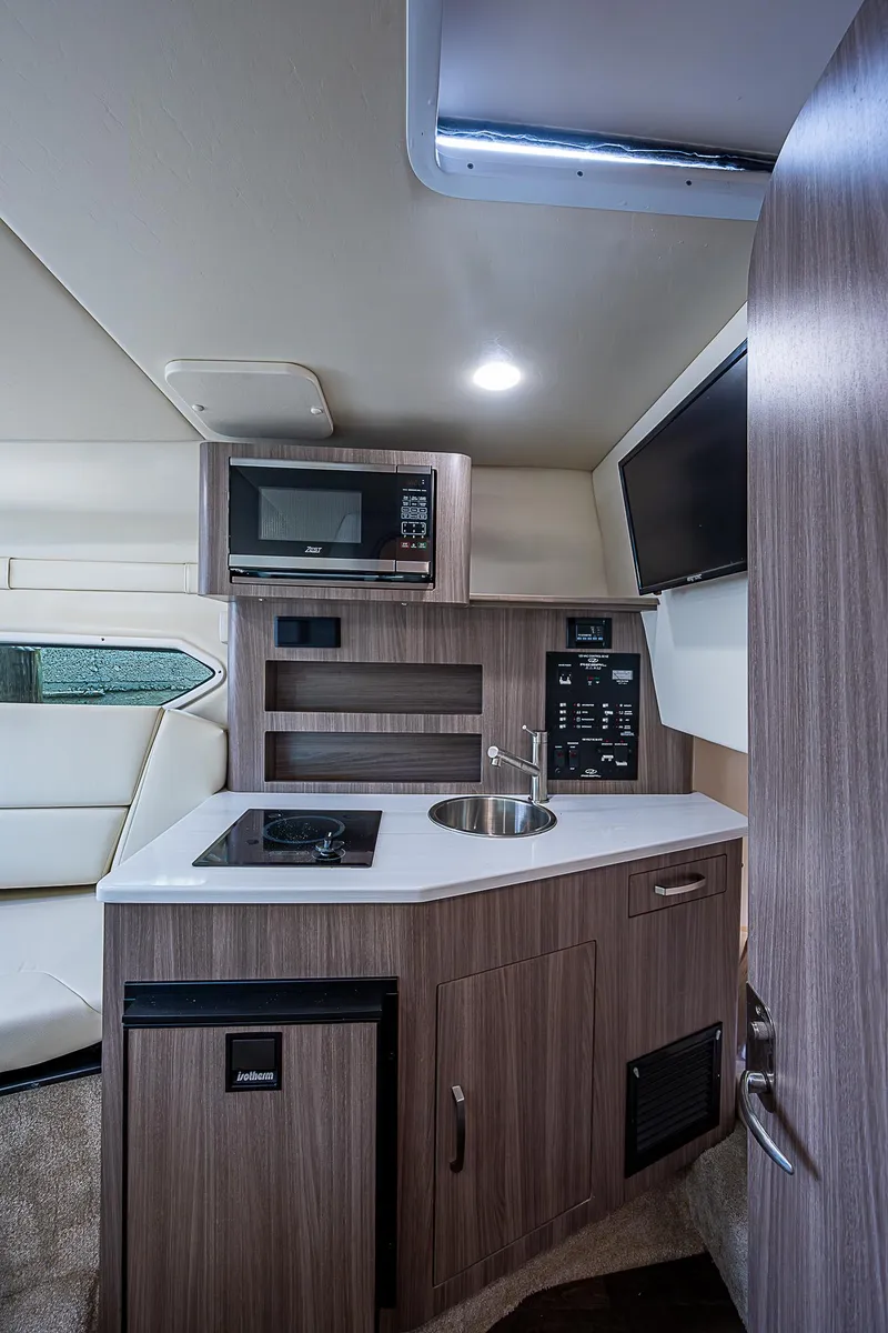 Slide: The Image of 2022 Regal 26 XO boat interior with kitchenette, microwave, and sink. - 8