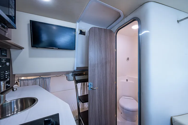 Slide: The Image of Interior of 2022 Regal 26 XO boat with kitchenette, TV, and bathroom. - 9