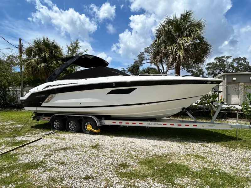 The Image of 2017 Cruisers Yachts 338 Sport Series on trailer, parked outdoors under a blue sky. - 1