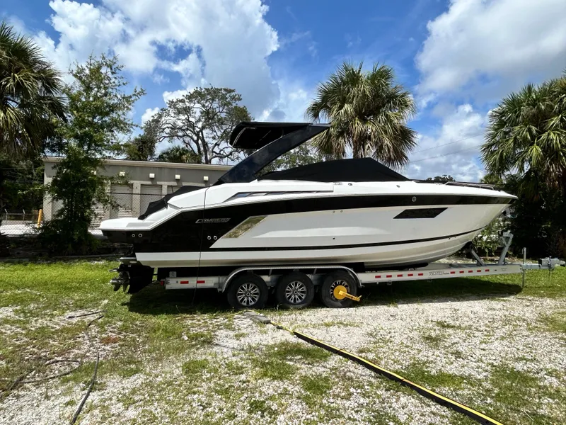 Slide: The Image of 2017 Cruisers Yachts 338 Sport Series boat on trailer, surrounded by palm trees. - 3
