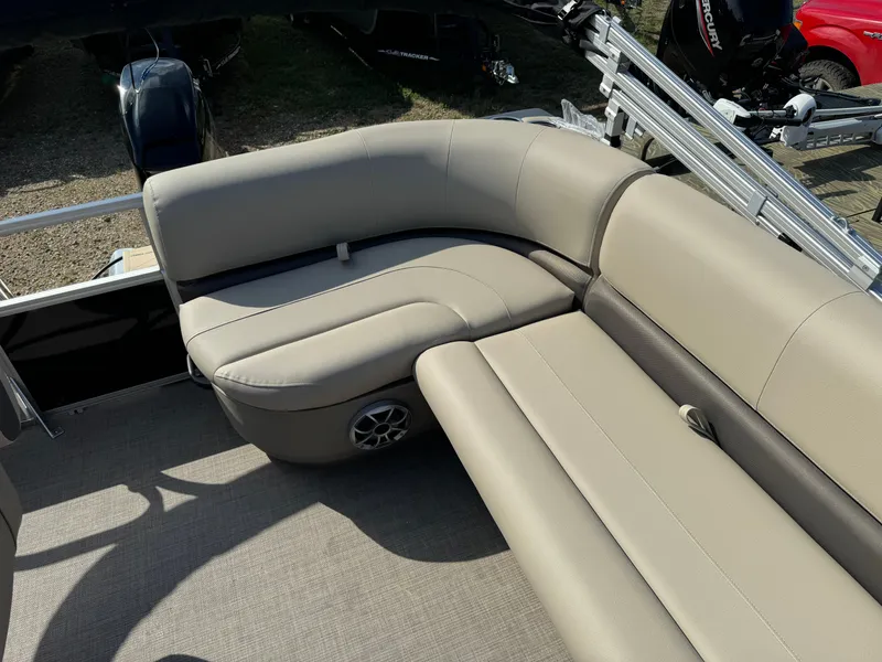 Slide: The Image of 2025 Sun Tracker Party Barge 16 DLX interior with beige seating and speaker. - 13
