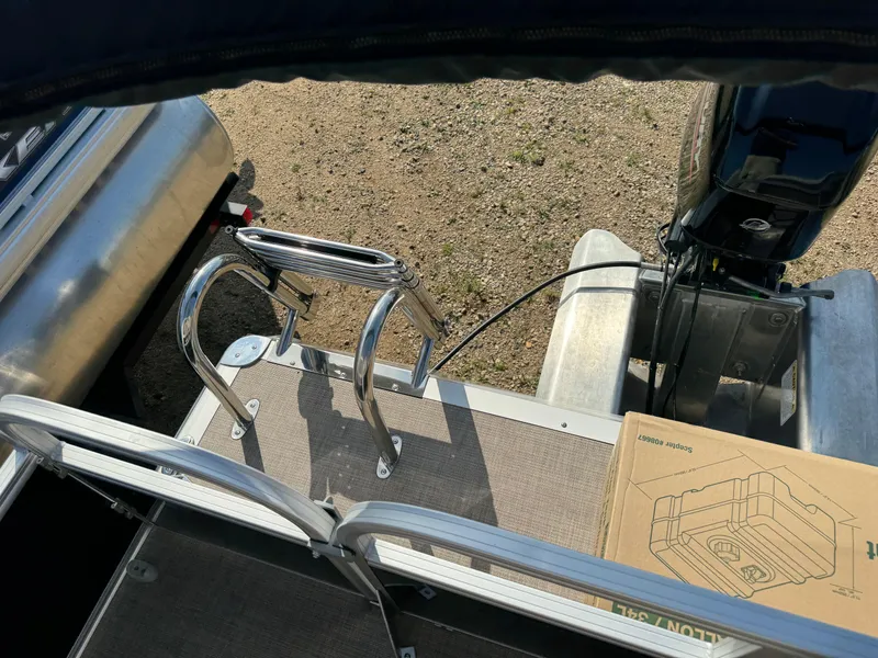 Slide: The Image of Sun Tracker Party Barge 16 DLX 2025, rear deck view with ladder and motor. - 17