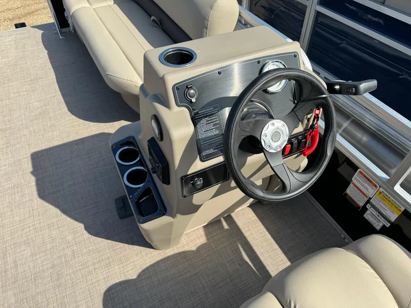 Slide: The Image of 2025 Sun Tracker Party Barge 16 DLX steering console with cup holders and seating. - 19