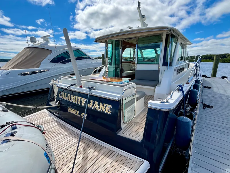 Slide: The Image of 2018 Sabre 45 Salon Express yacht "Calamity Jane" docked under a blue sky. - 14