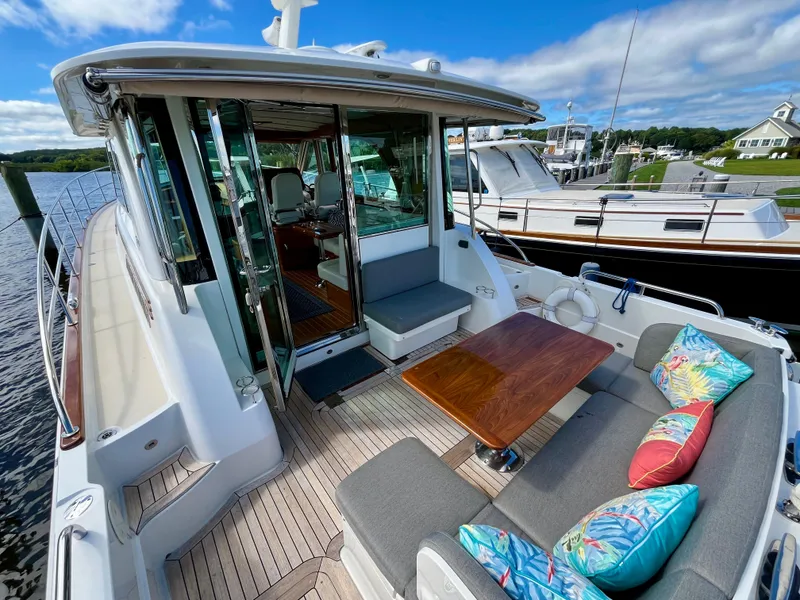 Slide: The Image of 2018 Sabre 45 Salon Express yacht with outdoor seating and colorful cushions. - 16