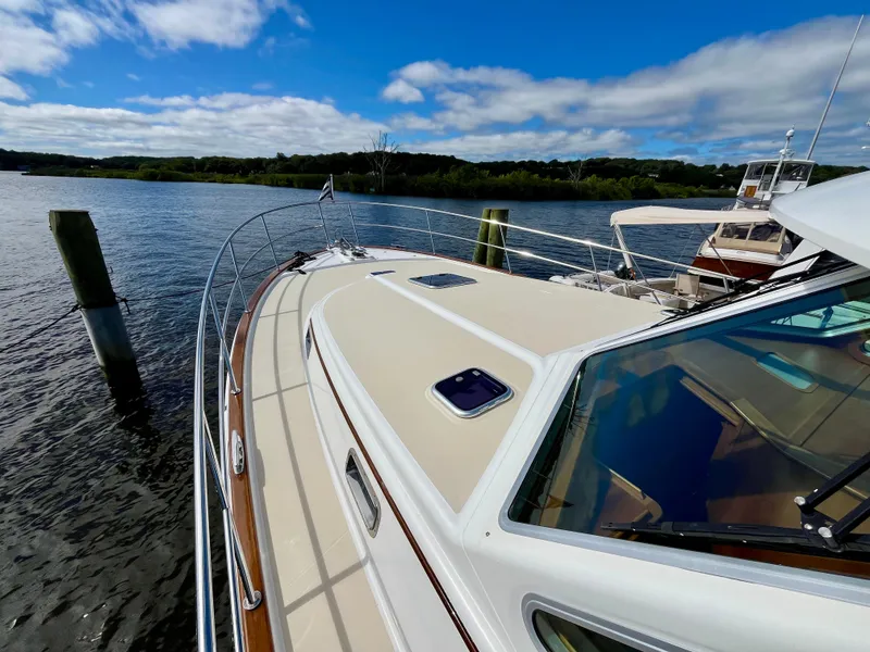 Slide: The Image of 2018 Sabre 45 Salon Express yacht on a serene lake under a blue sky. - 17