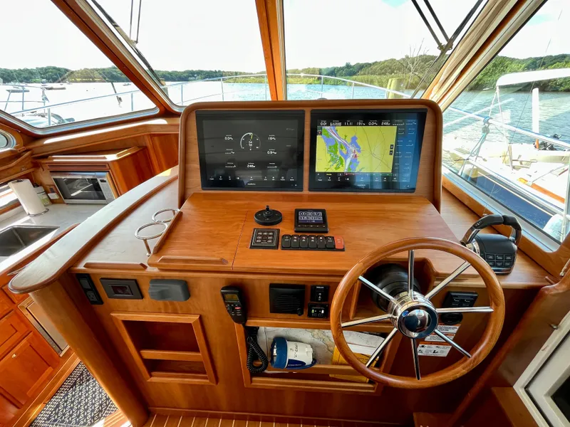 Slide: The Image of 2018 Sabre 45 Salon Express helm with navigation screens and wooden steering wheel. - 31