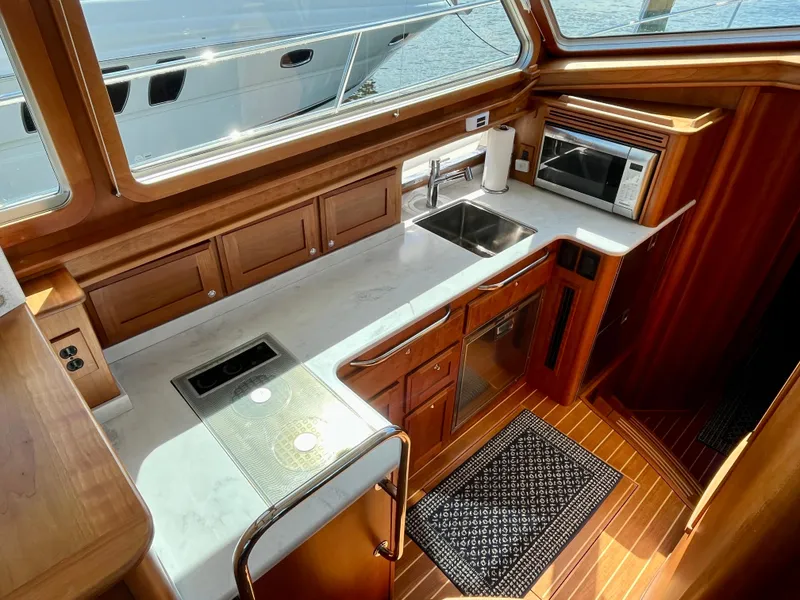 Slide: The Image of 2018 Sabre 45 Salon Express yacht kitchen with wood cabinetry and modern appliances. - 37