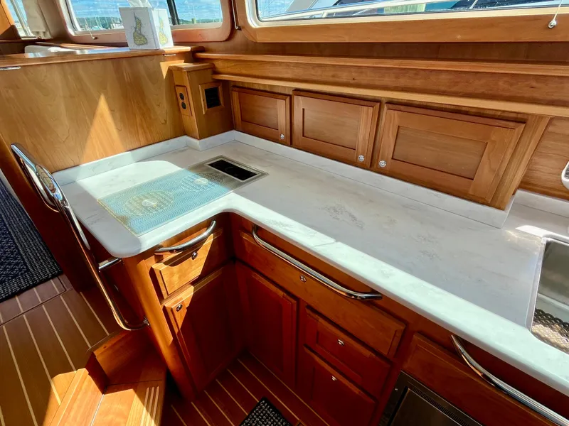 Slide: The Image of Luxurious 2018 Sabre 45 Salon Express yacht interior with elegant wood cabinetry and sleek countertops. - 39