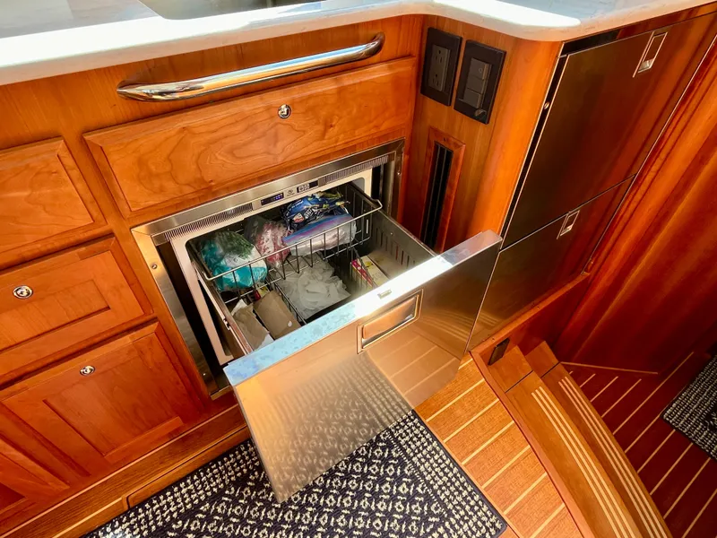 Slide: The Image of 2018 Sabre 45 Salon Express yacht kitchen with open stainless steel drawer and wooden cabinetry. - 41