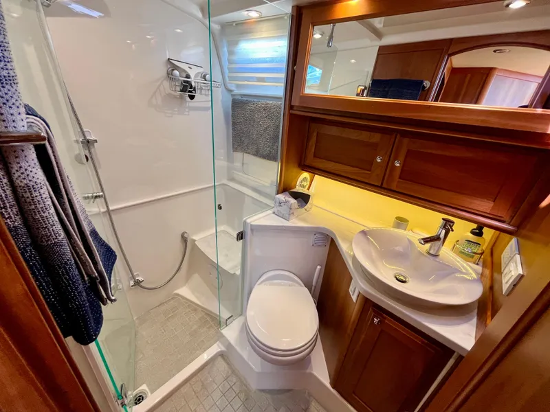 Slide: The Image of Luxurious bathroom in 2018 Sabre 45 Salon Express yacht with shower, sink, and wooden cabinetry. - 46
