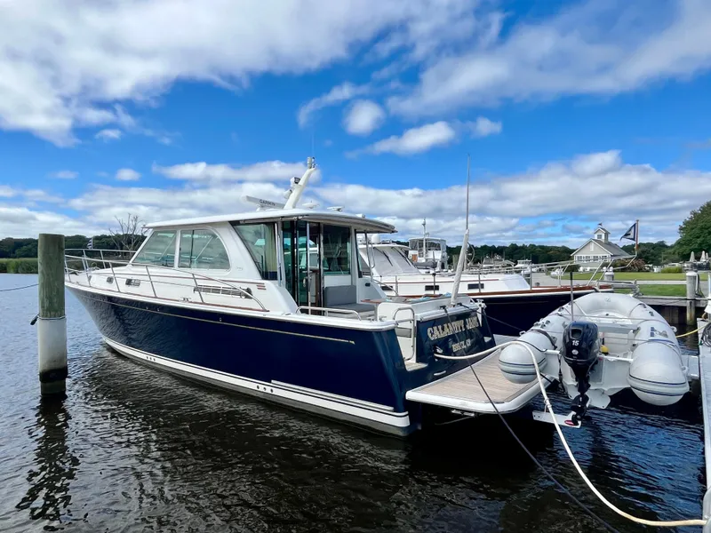Slide: The Image of 2018 Sabre 45 Salon Express yacht docked in a marina under a blue sky. - 7